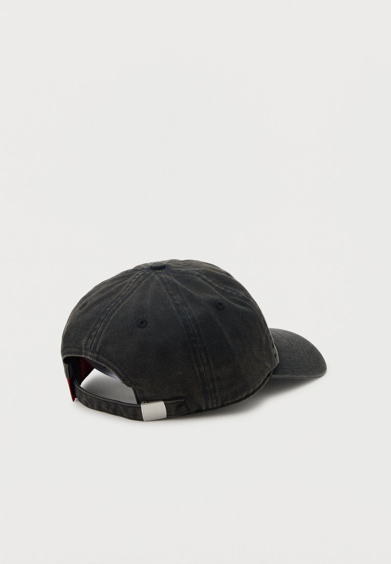 Casquette de baseball noire ajustable avec une boucle en métal, vue de dos sur un fond blanc.