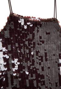 Top burdeos con lentejuelas y tirantes finos, que presenta lentejuelas circulares brillantes cosidas en una tela ligera, creando una superficie texturizada y reflectante.