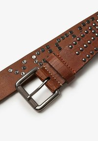 Bruine leren riem met metalen studs, een gestructureerde stalen gesp en contrasterende oranje stiksels. Heeft een breed, plat ontwerp en een gladde afwerking.