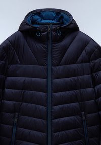 Chaqueta de plumas de color azul oscuro con capucha. Presenta acolchado de cuadros, cierre frontal de cremallera completa y cordones ajustables en la capucha. Acabado texturizado.