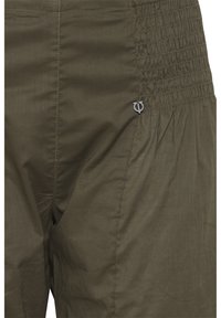 Pantaloni verde oliva con finitura testurizzata e cintura con elastico arricciato. Presenta un piccolo dettaglio del logo sul lato.