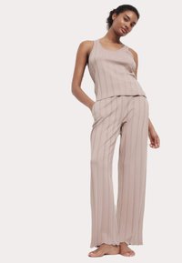 Beige rutigt lounge-set med en ärmlös topp med rund hals och vida byxor med sidofickor, tillverkat av mjukt och slätt tyg.