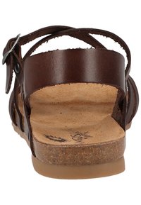 Sandalo in pelle marrone con cinturino regolabile, soletta in sughero e suola piana in gomma. Il design open back presenta ritagli orizzontali sui lati.