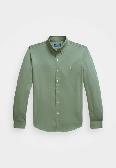 Camicia button-up a maniche lunghe in cotone verde oliva, con colletto a punta, patta frontale con bottoni e un piccolo logo sul petto.