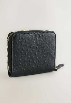 Schwarze Lederbörse mit einer strukturierten Oberfläche und erhabenen Punkten, einem goldenen Reißverschluss und einer kompakten rechteckigen Form.