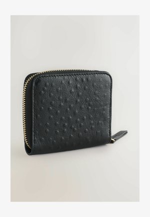 Schwarze Lederbörse mit einer strukturierten Oberfläche und erhabenen Punkten, einem goldenen Reißverschluss und einer kompakten rechteckigen Form.