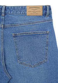Jeans in denim blu chiaro con taglio dritto, dotati di una singola tasca sul retro e un'etichetta beige con la scritta "DENIMWEAR CALLIOPE."