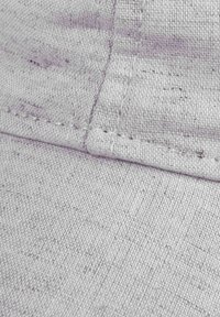 Hellgraue Kappe aus strukturiertem Material mit sichtbaren Nähten und einer stabilen Form. Der Stoff hat ein dezentes Muster und eine glatte Oberfläche.