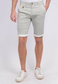 Shorts gris clair en tissu texturé, avec des revers, deux poches avant, une poche arrière et un bouton d'accent brun contrastant.