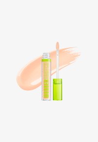 Tube transparent du NYX Wonder Stick avec capuchon vert et applicateur baguette à côté d'un échantillon de correcteur beige sur fond blanc.