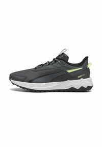 Chaussures de sport noires avec une tige en mesh, des accents réfléchissants et une semelle blanche en zigzag. Dotées d'une semelle extérieure en caoutchouc pour une meilleure traction.