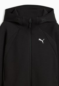 Felpa nera con zip e cappuccio, con logo Puma bianco sul petto, pannelli laterali in rete e coulisse regolabili.