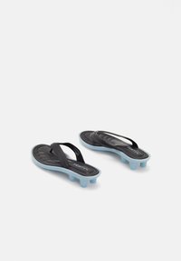 Black and light blue flip-flops with raised rounded heels and thong straps on a white background, branded with "FENTY".