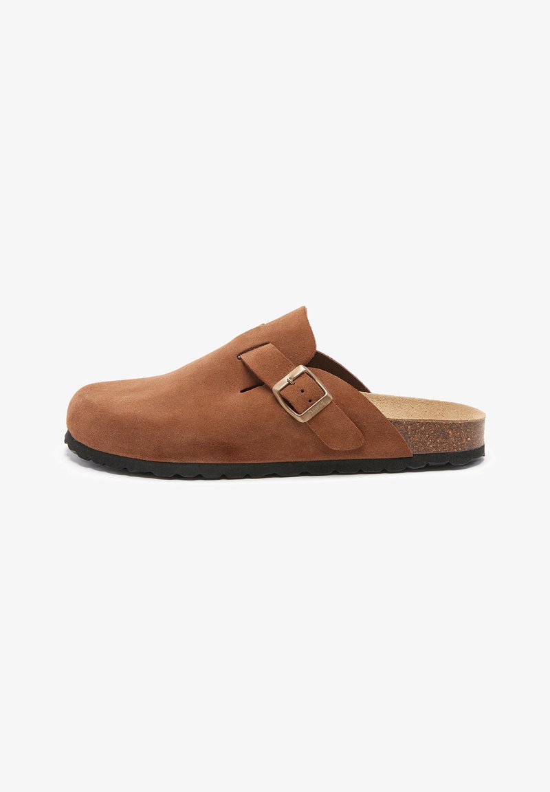 Sabots en cuir suédé marron à bout rond, avec une sangle à boucle ajustable, un semelle en liège et une semelle en caoutchouc texturé.