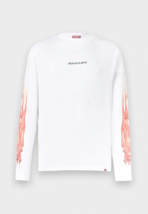 Chemise blanche à manches longues avec le logo "OAKLEY" sur la poitrine et des motifs de flammes orange courant le long des deux manches.