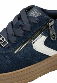 Navy suede sneaker with white leather accents, textured gum sole, metallic zipper detail, and gray laces.