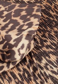 Brown and beige fabric with a leopard print design, featuring gathered texture and alternating horizontal lines for added detail.