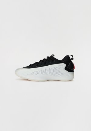 Scarpa atletica nera con pannello laterale in mesh bianco testurizzato, punta liscia e inserto sul tallone nero. Design leggero con suola arrotondata.