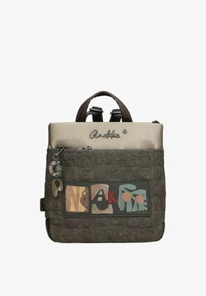 Brauner Leder-Rucksack mit einer strukturierten Oberfläche, einem beigen oberen Klappdeckel, dekorativen Buchstaben und Mustern. Verfügt über stabile Träger und einen kleinen Anhänger.