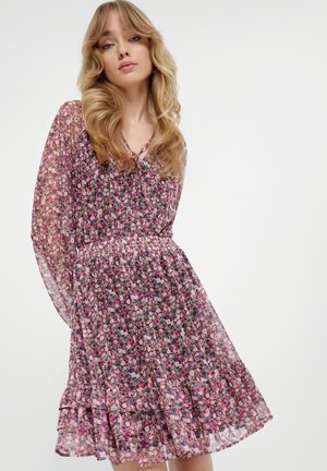 Floral dress in sheer material, featuring long sleeves, V-neck, and a tiered skirt. Predominantly pink with green and white accents.