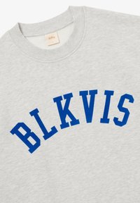 Sudadera gris claro de cuello redondo con letras azules en bloque que forman la palabra "BLKVIS" en forma de arco en el pecho, y una pequeña etiqueta de tela de la marca dentro del cuello.