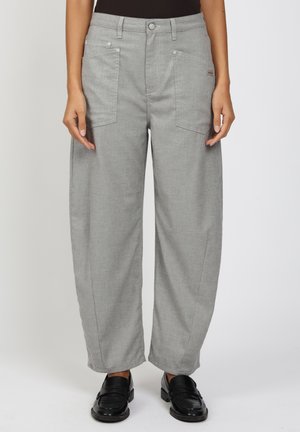 Person wearing gray wide-leg pants with front patch pockets and black loafers, standing against a plain background.