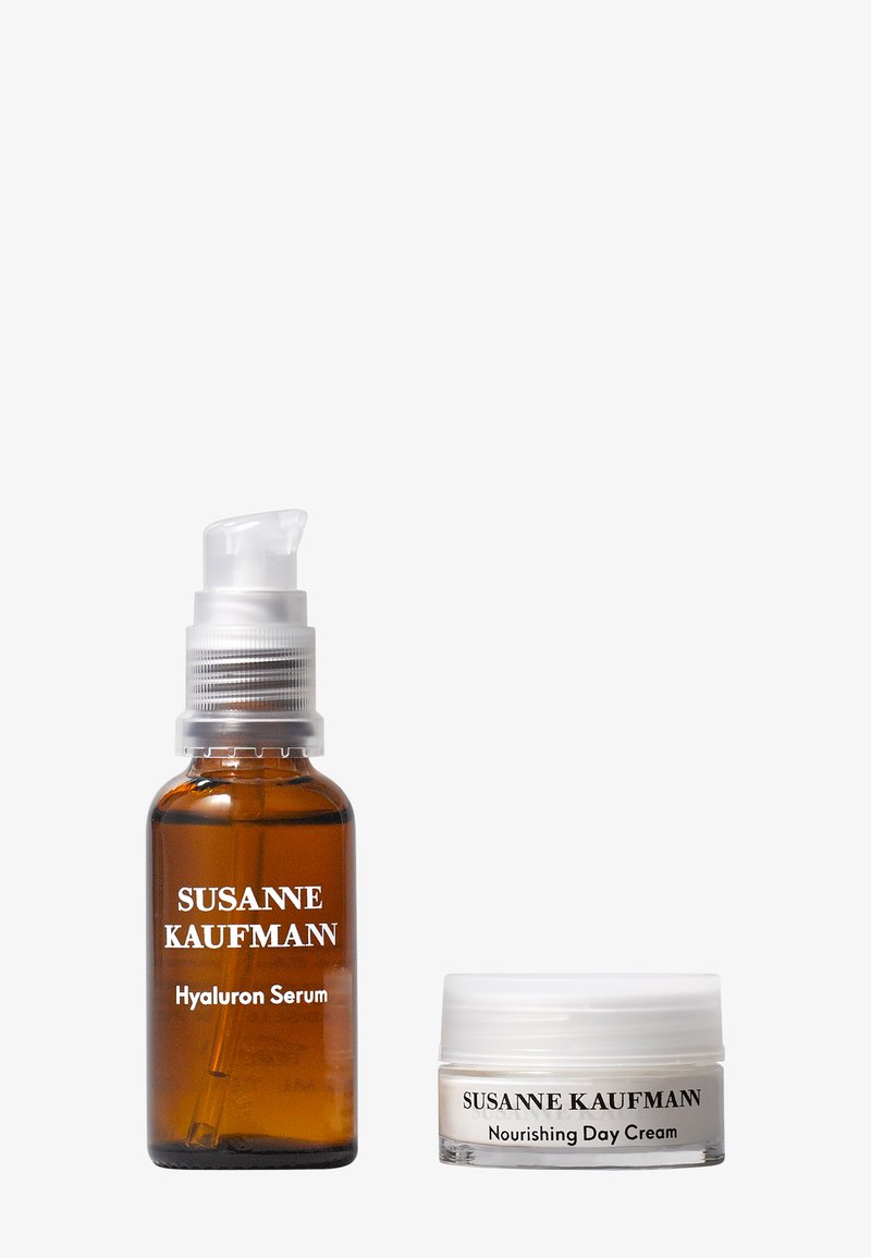 Brązowa szklana butelka z białą pompką oznaczona "Serum z kwasem hialuronowym" obok białego słoika oznaczonego "Odżywcza krem na dzień", obie z prostą, czytelną typografią.