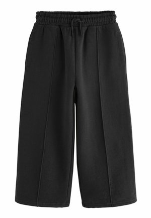 Pantalons larges noirs en coton doux avec une taille élastique et un cordon de serrage, dotés de deux poches latérales et de détails de couture visibles.