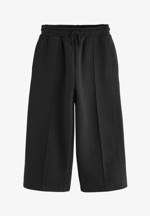 Fekete, bőszárú nadrág, puha pamutból készült, elasztikus derékrésszel és húzózsinórral, két oldalsó zsebbel és látható varrási részletekkel.