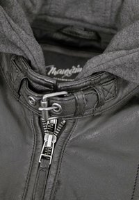 Schwarze Lederjacke mit grauem Kapuzenpullover, ausgestattet mit einem Metallreißverschluss, verstellbarem Kragen und gesteppten Details am Hals.