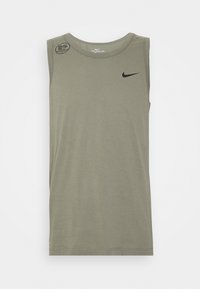 Oliwkowa koszulka bawełniana bez rękawów z okrągłym dekoltem, z czarnym logo Nike na piersi i okrągłym wzorem na ramieniu.