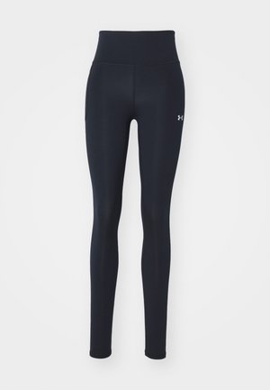 Leggings de sport noirs en tissu extensible, dotés d'une taille haute, de poches latérales et d'un petit logo sur le bas de la jambe.
