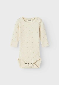 Långärmad babybodysuit i krämfärgad ribbad tyg, med små beige hjärt- mönster och tryckknappar i nederkanten för enkel byte.