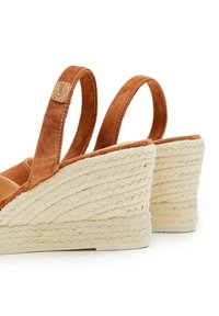 Sandalias de cuña de ante marrón con un tacón de yute trenzado texturizado. Tiras ajustables en la parte trasera y un forro interior suave.