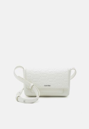 Sac bandoulière blanc Calvin Klein avec motif de logo embossé et bandoulière ajustable posé sur un fond uni.