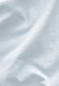 Világoskék anyag, puha, sima textúrával és enyhe fényű, amelyen finom szövésbeli eltérések találhatók a természetes hatás érdekében.