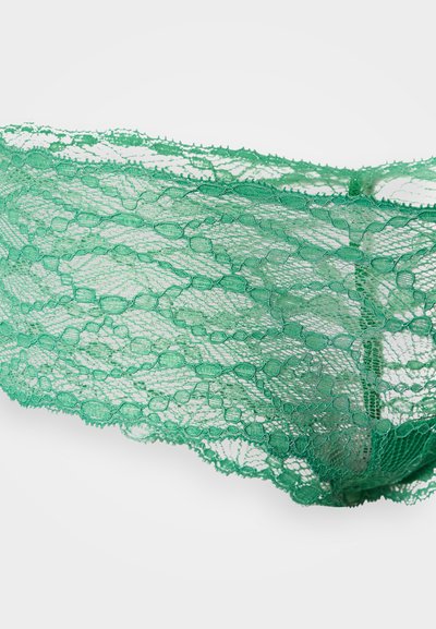 Zielona koronka z misternymi kwiatowymi wzorami i falistymi krawędziami, posiadająca przezroczystą fakturę podkreślającą jej delikatny wygląd.