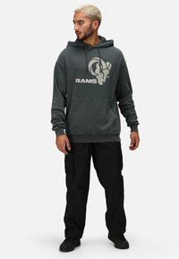 Dark gray hoodie with RAMS graphic, kangaroo pocket, and ribbed cuffs. Paired with black cargo pants and black sneakers.