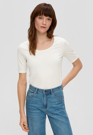 Witte korte mouwen top met een ronde hals, gecombineerd met blauwe high-waisted jeans. De stof lijkt zacht en aansluitend.