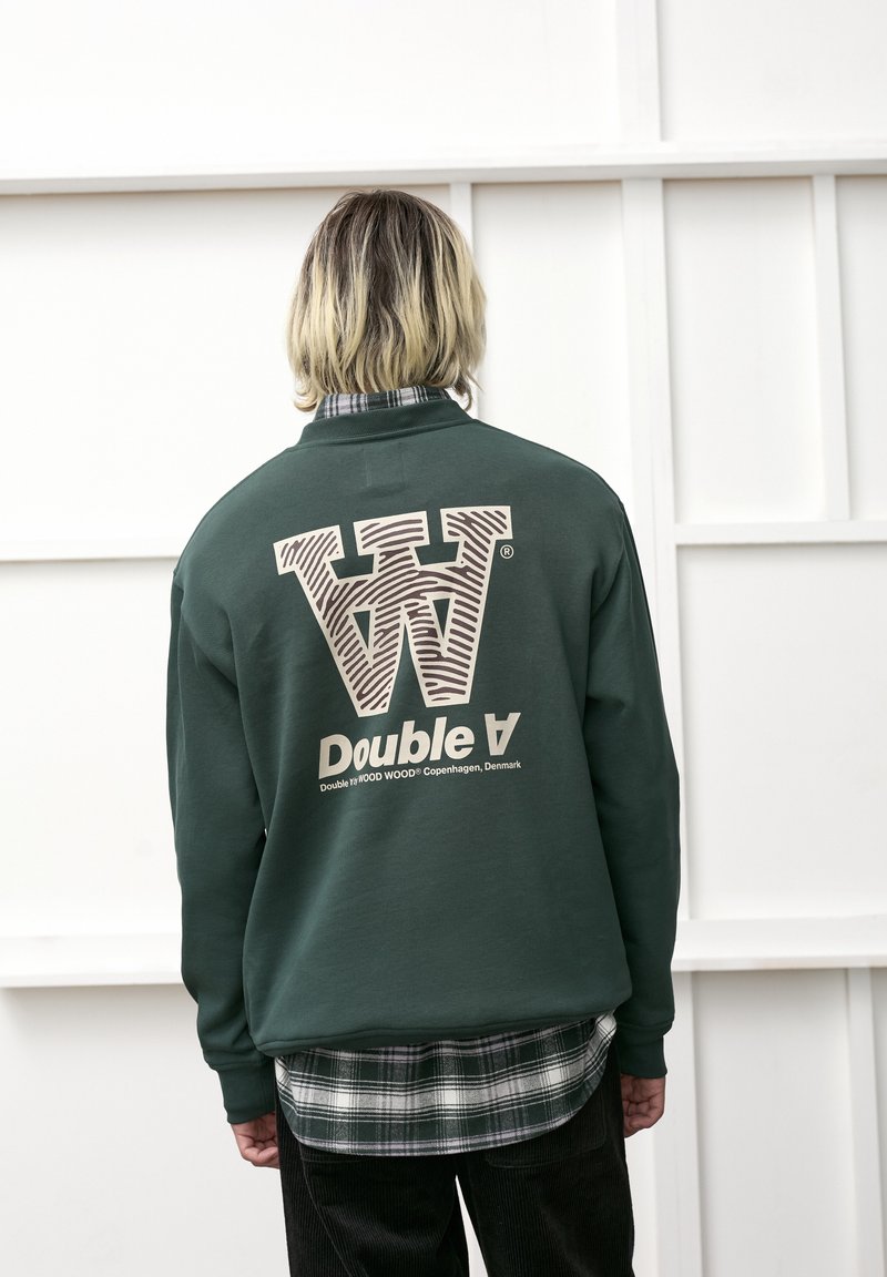 Grøn sweatshirt med et stort hvidt og brunt stribet logo "W" og "Double A" på ryggen; har en ribbet krave og struktureret stof.