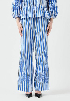 Pantalons larges rayés bleu et blanc avec broderies florales sur les côtés, fabriqués en tissu léger, présentant une coupe ample et un ourlet droit.