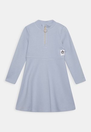 Robe à manches longues bleu clair avec col montant, fermeture éclair à l'avant avec tirette en forme d'anneau, et écusson logo visage de panda sur le côté droit.