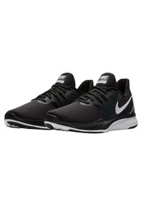 Černé sportovní boty s prodyšnou síťovanou vrchní částí, bílým logem Nike, texturovanou oblastí pro šněrování a polstrovanou černou podrážkou s bílými akcenty.