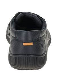 Sneaker in pelle nera con finitura testurizzata, tacco arrotondato e etichetta in pelle marrone a contrasto sul retro. Suola in gomma con scanalature verticali.