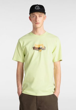 Helles grünes T-Shirt mit kurzen Ärmeln, Rundhalsausschnitt, das ein verspieltes Grafikdesign mit einem Vogel und einem Uhrenmotiv in der Mitte präsentiert.