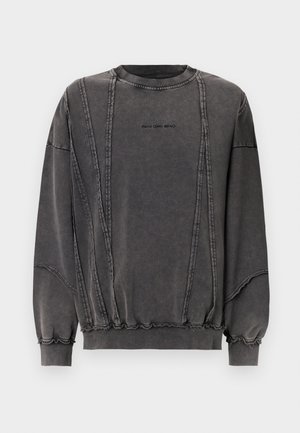 Grå bomulds sweatshirt med rund halsudskæring, kontrasterende syninger og samlet detalje ved kantene og ærmerne. Har et logo på fronten.