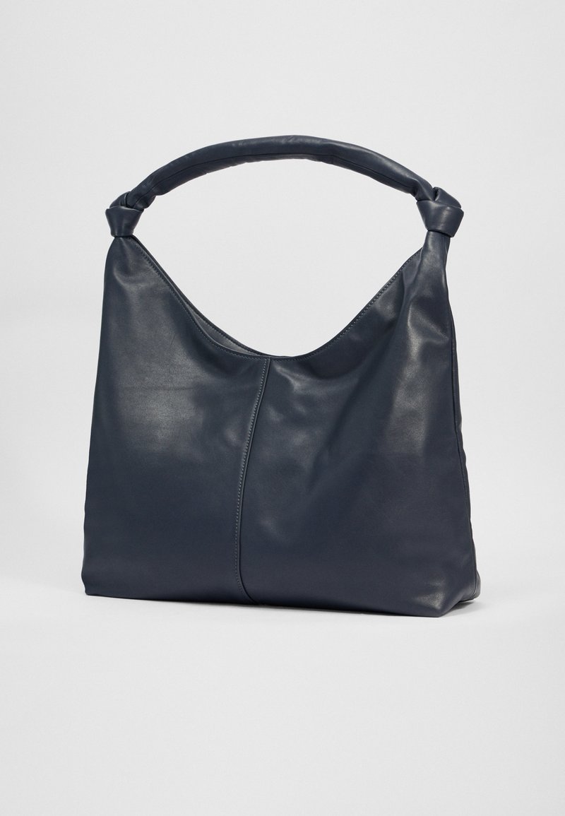 Marineblaue Leder-Schultertasche mit einer weichen, glatten Textur und einem geknoteten Griff. Verfügt über eine geschwungene Form und eine zentrale Naht für Stabilität.