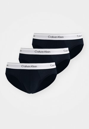 Czarny komplet bokserek bawełnianych z białym pasem elastykowym z logo "Calvin Klein", trzy sztuki starannie ułożone.