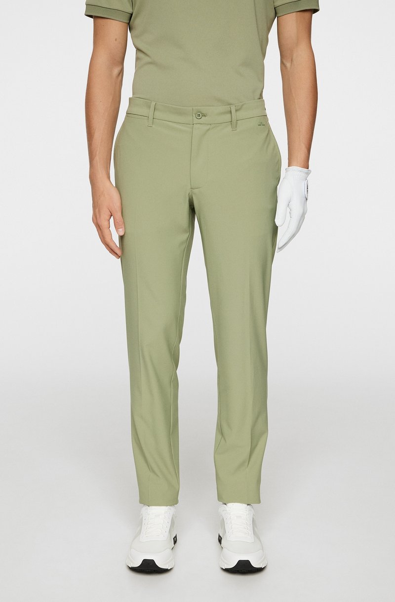 Herrgolfbyxor i ljusgrön, med en mjuk tygkvalitet, smal passform, standardfickor och enfaldig design. Bärs med en vit handske och skor.