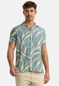 Short-sleeve shirt in light blue with a textured pattern and white leaf-like designs. Features a collar and button closure.